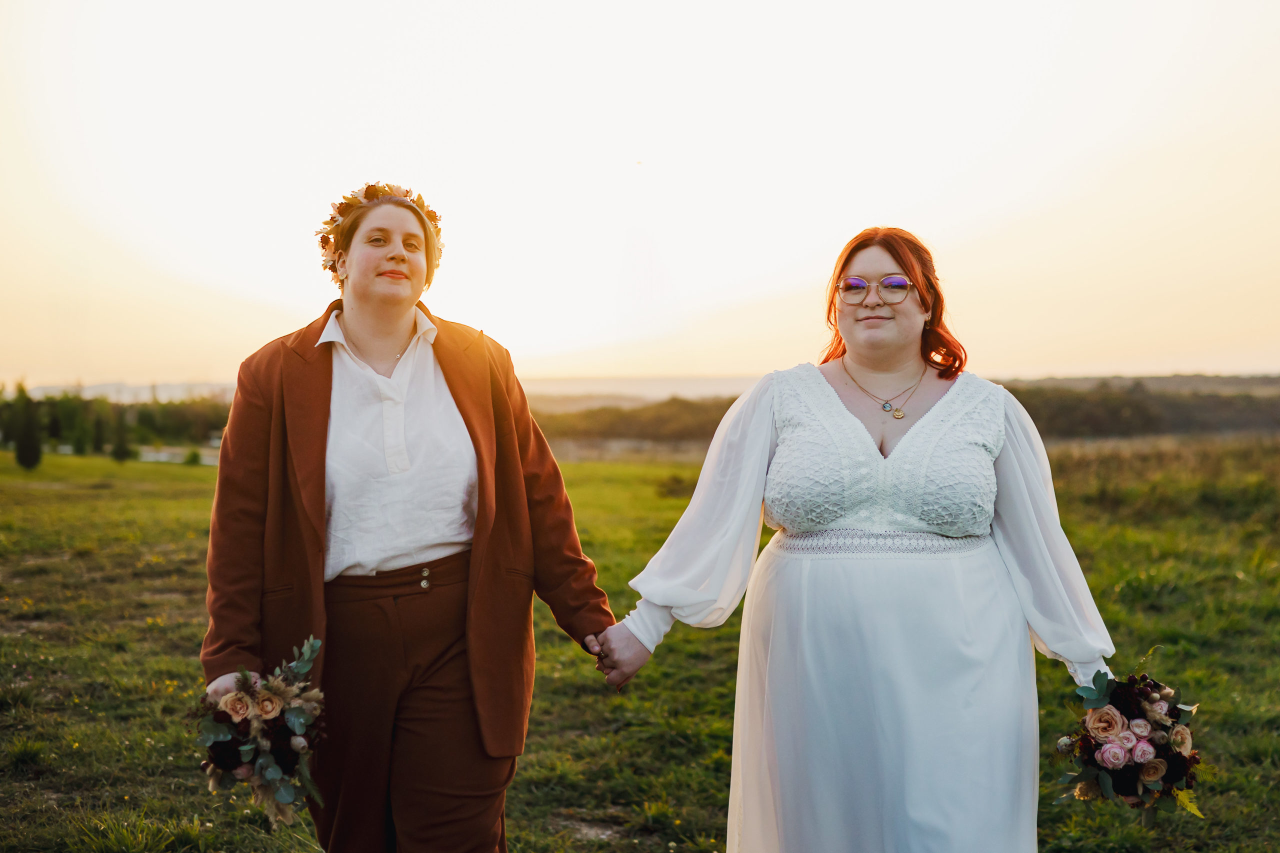 photo de couple, deux femmes qui marchent main dans la main au coucher de soleil